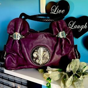 Unique purple, shoulder bag with lots of charm.